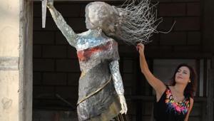 Lebanese artist, Hayat Nazer, poses near her statue made entirely out of broken glass and debris of the August 4 port explosion, during an interview with Reuters in Beirut, Lebanon November 10, 2020.(REUTERS) Lebanese artist, Hayat Nazer, poses near her statue made entirely out of broken glass and debris of the August 4 port explosion, during an interview with Reuters in Beirut, Lebanon November 10, 2020.(REUTERS)