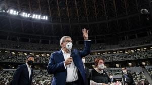IOC President Thomas Bach wearing a face mask waves as he speaks to the media at the National Stadium, the main venue for the 2020 Olympic and Paralympic Games postponed until July 2021 due to the coronavirus pandemic, in Tokyo Tuesday, Nov. 17, 2020. Bach said during this week's trip to Tokyo that he is “encouraging” all Olympic “participants” and fans to be vaccinated - if one becomes available - if they are going to attend next year's Tokyo Olympics. (Behrouz Mehri/Pool Photo via AP)(AP) IOC President Thomas Bach wearing a face mask waves as he speaks to the media at the National Stadium, the main venue for the 2020 Olympic and Paralympic Games postponed until July 2021 due to the coronavirus pandemic, in Tokyo Tuesday, Nov. 17, 2020. Bach said during this week's trip to Tokyo that he is “encouraging” all Olympic “participants” and fans to be vaccinated - if one becomes available - if they are going to attend next year's Tokyo Olympics. (Behrouz Mehri/Pool Photo via AP)(AP)