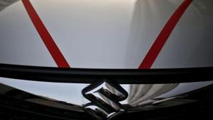 The logo of Maruti Suzuki India Limited is seen on car parked outside a showroom in New Delhi (REUTERS/File Photo).