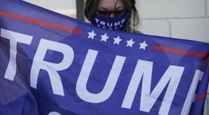 A supporter of President Donald Trump holds a flag during a news conference Tuesday, Nov. 17, 2020, in Las Vegas. (AP Photo/John Locher) A supporter of President Donald Trump holds a flag during a news conference Tuesday, Nov. 17, 2020, in Las Vegas. (AP Photo/John Locher)