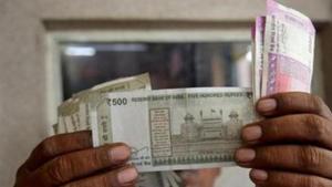 A cashier checks rupee notes inside a room at a fuel station in Ahmedabad.(REUTERS) A cashier checks rupee notes inside a room at a fuel station in Ahmedabad.(REUTERS)