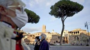 People wearing masks take a walk in Rome.(AP) People wearing masks take a walk in Rome.(AP)