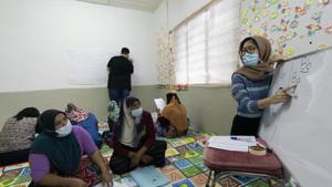 A volunteer teacher, right, gives a basic English lesson to a minority Muslim Rohingya refugees at a slum on the outskirts of Kuala Lumpur, Malaysia.(AP) A volunteer teacher, right, gives a basic English lesson to a minority Muslim Rohingya refugees at a slum on the outskirts of Kuala Lumpur, Malaysia.(AP)