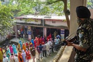 A security official keeps a vigil as people stand in queues to cast their votes at a polling station during the Bihar assembly elections at Mahua in Vaishali district.(PTI FILE) A security official keeps a vigil as people stand in queues to cast their votes at a polling station during the Bihar assembly elections at Mahua in Vaishali district.(PTI FILE)