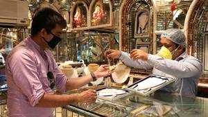 A salesman shows gold necklaces to a customer at a jewellery showroom in Kolkata.(Reuters Photo) A salesman shows gold necklaces to a customer at a jewellery showroom in Kolkata.(Reuters Photo)