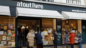 People queue at the 'click and collect' service of bookshop "Atout Livre" in Paris as all non-essential stores are closed in France to combat the coronavirus disease outbreak, France.(REUTERS) People queue at the 'click and collect' service of bookshop "Atout Livre" in Paris as all non-essential stores are closed in France to combat the coronavirus disease outbreak, France.(REUTERS)
