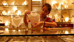 A saleswoman displays a gold necklace inside a jewellery showroom in Kolkata in this file photo.(Reuters Photo) A saleswoman displays a gold necklace inside a jewellery showroom in Kolkata in this file photo.(Reuters Photo)