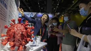 An employee answers questions from the public near samples of a Covid-19 vaccine produced by Sinopharm subsidiary CNBG are displayed during a trade fair in Beijing on September 6.(AP file) An employee answers questions from the public near samples of a Covid-19 vaccine produced by Sinopharm subsidiary CNBG are displayed during a trade fair in Beijing on September 6.(AP file)