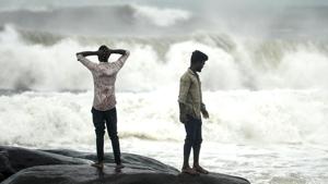 People stand on a rock while waves lash at Kovalam beach as Cyclone Nivar approaches the eastern Indian coast, in Chennai.(AFP) People stand on a rock while waves lash at Kovalam beach as Cyclone Nivar approaches the eastern Indian coast, in Chennai.(AFP)