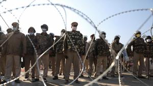 Police officers gather behind barbed wires to stop farmers opposing the newly passed farm bills from entering the national capital Delhi, at Singhu border, India, November 27, 2020.(REUTERS) Police officers gather behind barbed wires to stop farmers opposing the newly passed farm bills from entering the national capital Delhi, at Singhu border, India, November 27, 2020.(REUTERS)