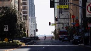 A person crosses an empty Grand Ave in downtown during the outbreak of the coronavirus disease in Los Angeles, California.(REUTERS) A person crosses an empty Grand Ave in downtown during the outbreak of the coronavirus disease in Los Angeles, California.(REUTERS)