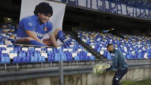Napoli's Lorenzo Insigne lays a bouquet of flowers under a photo of Diego Armando Maradona exposed at the San Paolo stadium.(AP) Napoli's Lorenzo Insigne lays a bouquet of flowers under a photo of Diego Armando Maradona exposed at the San Paolo stadium.(AP)