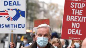 Demonstrator hold placards as EU chief negotiator Michel Barnier walks through central London on November 30, 2020 after leaving the conference centre where talks continue on a trade deal between the EU and the UK.(AFP) Demonstrator hold placards as EU chief negotiator Michel Barnier walks through central London on November 30, 2020 after leaving the conference centre where talks continue on a trade deal between the EU and the UK.(AFP)