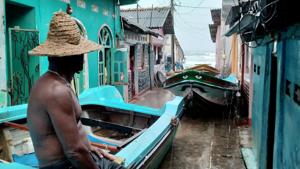 A fisherman sits on the top of a boat after pulling it back to land as the cyclone Burevi is expected to near the coast of Trincomalee, Sri Lanka December 2, 2020.(Reuters photo) A fisherman sits on the top of a boat after pulling it back to land as the cyclone Burevi is expected to near the coast of Trincomalee, Sri Lanka December 2, 2020.(Reuters photo)
