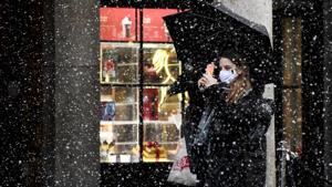 A woman wearing a face mask takes a photo on her phone in Covent Garden, London, Thursday, Dec. 3, 2020.(AP photo) A woman wearing a face mask takes a photo on her phone in Covent Garden, London, Thursday, Dec. 3, 2020.(AP photo)