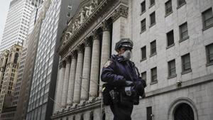 An NYPD officer walks along a sparsely populated Wall Street in the Manhattan borough of New York.(Representational Image / AP) An NYPD officer walks along a sparsely populated Wall Street in the Manhattan borough of New York.(Representational Image / AP)