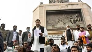RJD leader Tejashwi Yadav speaks next to the statue of Mahatma Gandhi while on dharna with Congress and RJD workers at Gandhi Maidan in protest against new farm laws, in Patna, Bihar. A case was filed against Yadav and 18 other leaders from the constituents of the Grand Alliance-led opposition in Bihar for protesting without permission amid the coronavirus pandemic.(Photo by Santosh Kumar/ Hindustan Times) RJD leader Tejashwi Yadav speaks next to the statue of Mahatma Gandhi while on dharna with Congress and RJD workers at Gandhi Maidan in protest against new farm laws, in Patna, Bihar. A case was filed against Yadav and 18 other leaders from the constituents of the Grand Alliance-led opposition in Bihar for protesting without permission amid the coronavirus pandemic.(Photo by Santosh Kumar/ Hindustan Times)