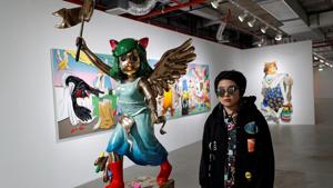 Thai artist Yuree Kensaku poses next to her sculpture titled 