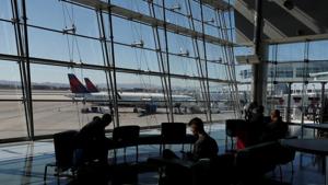 Travelers sit in a lounge area as Delta Air Lines plane park at a gate in McCarran International Airport in Las Vegas, Nevada, US.(Reuters) Travelers sit in a lounge area as Delta Air Lines plane park at a gate in McCarran International Airport in Las Vegas, Nevada, US.(Reuters)