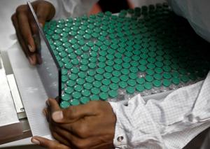 An employee in personal protective equipment (PPE) removes vials of AstraZeneca's COVISHIELD, coronavirus disease (COVID-19) vaccine from a visual inspection machine inside a lab at Serum Institute of India, in Pune.(REUTERS) An employee in personal protective equipment (PPE) removes vials of AstraZeneca's COVISHIELD, coronavirus disease (COVID-19) vaccine from a visual inspection machine inside a lab at Serum Institute of India, in Pune.(REUTERS)