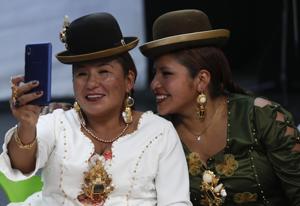 Aymara models take a selfie before performing at a Chola fashion parade in La Paz, Bolivia, Friday, Dec. 4, 2020. Designers and manufacturers of Chola clothing seek to reactivate their economy with the parade. The event is named after Remedios Loza, the first woman in a skirt to be elected to the Bolivian Parliament. (AP) Aymara models take a selfie before performing at a Chola fashion parade in La Paz, Bolivia, Friday, Dec. 4, 2020. Designers and manufacturers of Chola clothing seek to reactivate their economy with the parade. The event is named after Remedios Loza, the first woman in a skirt to be elected to the Bolivian Parliament. (AP)