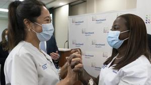 Nurse Annabelle Jimenez, left, congratulates nurse Sandra Lindsay after she was inoculated with the Pfizer-BioNTech Covid-19 vaccine on Monday at the Jewish Medical Center, in the Queens borough of New York.(AP) Nurse Annabelle Jimenez, left, congratulates nurse Sandra Lindsay after she was inoculated with the Pfizer-BioNTech Covid-19 vaccine on Monday at the Jewish Medical Center, in the Queens borough of New York.(AP)