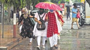 Pedestrians caught in rains at Sector-10 Vashi in Navi Mumbai, on Monday.(Bachchan Kumar/ HT PHOTO)