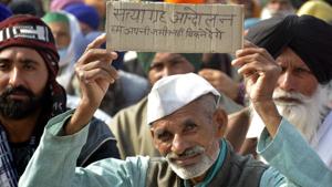 A demonstrator holds up a placard while sitting at the National Highway-9 (NH9) blockade, near the Ghazipur protest site, in Ghaziabad on Tuesday.(Sakib Ali/HT Photo) A demonstrator holds up a placard while sitting at the National Highway-9 (NH9) blockade, near the Ghazipur protest site, in Ghaziabad on Tuesday.(Sakib Ali/HT Photo)