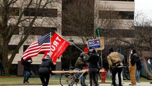 Supporters of President Donald Trump and a supporter of President-elect Joe Biden stand outside the Michigan state capital as the Electoral College votes in Lansing, Michigan.(AFP) Supporters of President Donald Trump and a supporter of President-elect Joe Biden stand outside the Michigan state capital as the Electoral College votes in Lansing, Michigan.(AFP)