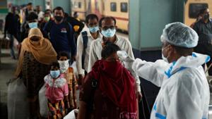 A health worker in personal protective equipment (PPE) checks the temperature of passengers amid the spread of the coronavirus disease at a railway station in Mumbai, India, December 11, 2020.(REUTERS) A health worker in personal protective equipment (PPE) checks the temperature of passengers amid the spread of the coronavirus disease at a railway station in Mumbai, India, December 11, 2020.(REUTERS)
