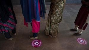 Markings made to ensure social distancing are seen on the floor as women queue up to vote for local body elections in Kochi, Kerala.(AP) Markings made to ensure social distancing are seen on the floor as women queue up to vote for local body elections in Kochi, Kerala.(AP)