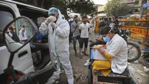 A health worker gets ready to take samples from people to test for Covid-19 as another registers them at a marketplace in New Delhi.(AP Photo) A health worker gets ready to take samples from people to test for Covid-19 as another registers them at a marketplace in New Delhi.(AP Photo)