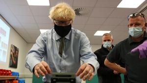 Britain's Prime Minister Boris Johnson tries his hand at cable splicing during a visit to the Openreach Learning and Development Training Centre in Bolton, Greater Manchester, northwest England, on December 18, 2020.(AFP) Britain's Prime Minister Boris Johnson tries his hand at cable splicing during a visit to the Openreach Learning and Development Training Centre in Bolton, Greater Manchester, northwest England, on December 18, 2020.(AFP)