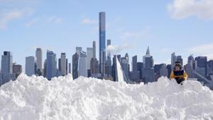 A child plays on a mound of snow in New York City on December 17. A Nor’easter storm buried parts of upstate New York and Northeastern United States in snow, breaking records in cities and towns across the region, and left plough drivers struggling to clear the roads as snow piled up at more than 4 inches per hour, AP reported. (Seth Wenig / AP) A child plays on a mound of snow in New York City on December 17. A Nor’easter storm buried parts of upstate New York and Northeastern United States in snow, breaking records in cities and towns across the region, and left plough drivers struggling to clear the roads as snow piled up at more than 4 inches per hour, AP reported. (Seth Wenig / AP)