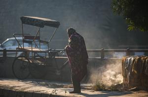 A man wrapped in a blanket stands near a pile of burning garbage on a cold day, at Kashmere Gate on Friday.(Amal KS/HT PHOTO) A man wrapped in a blanket stands near a pile of burning garbage on a cold day, at Kashmere Gate on Friday.(Amal KS/HT PHOTO)