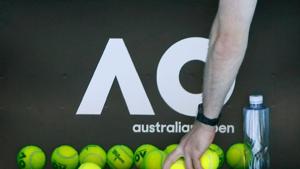 Tennis - Australian Open - Melbourne, Australia, January 14, 2018. A person picks up tennis balls in front of the Australian Open logo before the tennis tournament. REUTERS/Thomas Peter/Files(REUTERS) Tennis - Australian Open - Melbourne, Australia, January 14, 2018. A person picks up tennis balls in front of the Australian Open logo before the tennis tournament. REUTERS/Thomas Peter/Files(REUTERS)