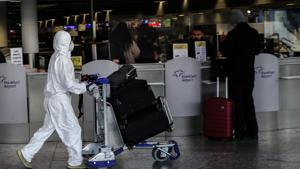 A passenger wearing a protective suit pushes a luggage cart at Frankfurt International Airport in Frankfurt am Main, western Germany.(AFP) A passenger wearing a protective suit pushes a luggage cart at Frankfurt International Airport in Frankfurt am Main, western Germany.(AFP)