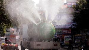 A municipal corporation tanker sprays water on trees to reduce air pollution in Prayagraj on Saturday.(ANI)