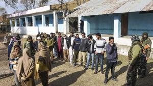 Poonch: Security personnel stand guard as residents queue to cast their votes during re-polling of DDC elections, at a booth in Poonch district, Monday, Dec. 21, 2020. (PTI Photo) Poonch: Security personnel stand guard as residents queue to cast their votes during re-polling of DDC elections, at a booth in Poonch district, Monday, Dec. 21, 2020. (PTI Photo)