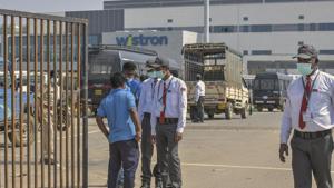 Security personnel stand guard outside Wistron Infocomm Manufacturing India Pvt Ltd, where a section of workers went on a rampage at its facility manufacturing Apple iPhones and other products over non-payment of promised wage, at Narasapura area in Bengaluru, Sunday, Dec. 13, 2020.(PTI) Security personnel stand guard outside Wistron Infocomm Manufacturing India Pvt Ltd, where a section of workers went on a rampage at its facility manufacturing Apple iPhones and other products over non-payment of promised wage, at Narasapura area in Bengaluru, Sunday, Dec. 13, 2020.(PTI)