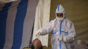 New Delhi, India - Dec. 23, 2020: A health worker in PPE coveralls collects a swab sample from a person for coronavirus screening at a temporary testing facility in Sarai Kale Khan, New Delhi, India, on Wednesday, December 23, 2020. (Photo by Biplov Bhuyan/ Hindustan Times) New Delhi, India - Dec. 23, 2020: A health worker in PPE coveralls collects a swab sample from a person for coronavirus screening at a temporary testing facility in Sarai Kale Khan, New Delhi, India, on Wednesday, December 23, 2020. (Photo by Biplov Bhuyan/ Hindustan Times)