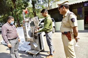 A police official demonstrates the functioning of the seized gutkha making machine in Bhosari.(HT PHOTO)