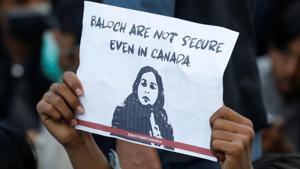 A person holds a placard to condemn the death of Karima Baloch, a Pakistani human rights activist living in Canada, who went missing and was found dead.(REUTERS) A person holds a placard to condemn the death of Karima Baloch, a Pakistani human rights activist living in Canada, who went missing and was found dead.(REUTERS)