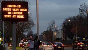 Pedestrians walks past a public health warning sign beside a road, amidst the spread of the coronavirus disease (COVID-19) pandemic, London, Britain.(REUTERS) Pedestrians walks past a public health warning sign beside a road, amidst the spread of the coronavirus disease (COVID-19) pandemic, London, Britain.(REUTERS)