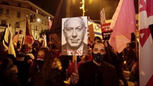 Israeli protesters hold signs during a demonstration against Israeli Prime Minister Benjamin Netanyahu in Jerusalem.(AP) Israeli protesters hold signs during a demonstration against Israeli Prime Minister Benjamin Netanyahu in Jerusalem.(AP)