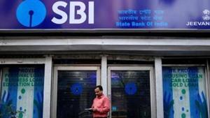 A man checks his mobile phones in front of State Bank of India (SBI) branch in Kolkata.(REUTERS) A man checks his mobile phones in front of State Bank of India (SBI) branch in Kolkata.(REUTERS)