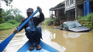 A man rows a boat along a flooded street caused by heavy rain in Indonesia’s Bandung on December 25, 2020. (Photo by Timur Matahari / AFP)(AFP) A man rows a boat along a flooded street caused by heavy rain in Indonesia’s Bandung on December 25, 2020. (Photo by Timur Matahari / AFP)(AFP)