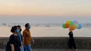 People walk past a girl selling balloons near the sea front in Mumbai on December 27. India recorded 16,432 new cases of the coronavirus disease (Covid-19) cases, according to Union health ministry update on December 29. However, of India’s total tally of cases, more than 9.8 million or nearly 96% patients have defeated the disease. (AFP) People walk past a girl selling balloons near the sea front in Mumbai on December 27. India recorded 16,432 new cases of the coronavirus disease (Covid-19) cases, according to Union health ministry update on December 29. However, of India’s total tally of cases, more than 9.8 million or nearly 96% patients have defeated the disease. (AFP)