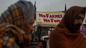 Farmers stand next to a fire as they warm themselves on a cold winter morning at the site of a protest against new farm laws, at Singhu border, near New Delhi.(REUTERS) Farmers stand next to a fire as they warm themselves on a cold winter morning at the site of a protest against new farm laws, at Singhu border, near New Delhi.(REUTERS)