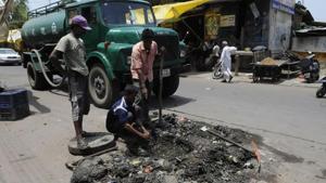 Sanitary workers clear a choked drainage chamber in Nandlalpura area in Indore.(Representative Photo/HT) Sanitary workers clear a choked drainage chamber in Nandlalpura area in Indore.(Representative Photo/HT)